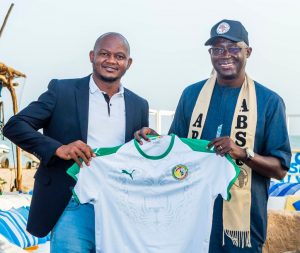 Taye with CAF vice president Augustin Sengor being presented with a Jersey in Senegal